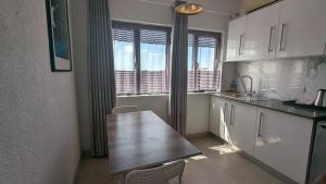 a kitchen with a wooden table and a counter top at Ibis Tourist Residence 1 in Mahébourg