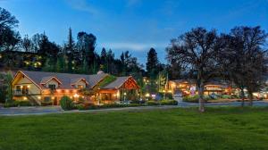 a large house with a green lawn in front of it at Best Western Plus Yosemite Gateway Inn in Oakhurst