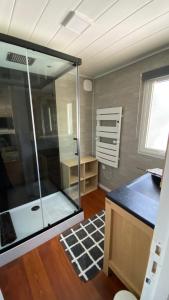 uma casa de banho com um chuveiro de vidro num quarto em Bungalow de luxe de 60m2 dans camping 5 étoiles em Puget-sur Argens
