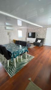 a living room with a table and a couch at Bungalow de luxe de 60m2 dans camping 5 étoiles in Puget-sur-Argens