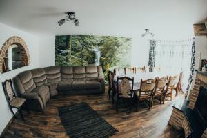 a living room with a couch and a table and chairs at Casa Costea in Gura Humorului