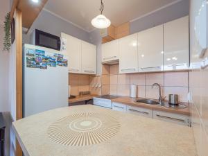 a kitchen with white cabinets and a white refrigerator at Mieszkanie Centrum in Iława