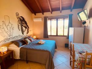 a bedroom with two beds and a refrigerator in it at Pousada Caminho do Mar MADHOUZE in Garopaba