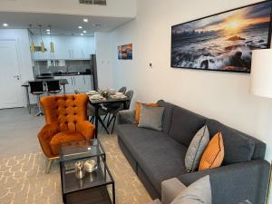 uma sala de estar com um sofá e uma mesa em Birchfort - Newly renovated unique 1 bedroom apartment no Dubai