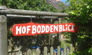 Ein Schild, das über einem Zaun hängt, mit den Worten "hog backyardicked" in der Unterkunft Hofboddenblick in Kückenshagen