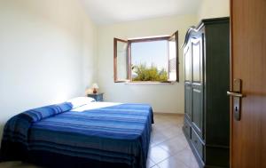 クストナーチにあるVilla Alle Falde di Cofanoのベッドルーム1室(青い毛布、窓付)