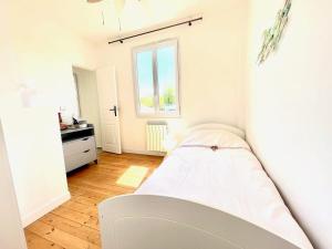 biała sypialnia z łóżkiem i oknem w obiekcie Très jolie Villa Bianca, maison avec jardin privé à Deauville w mieście Deauville