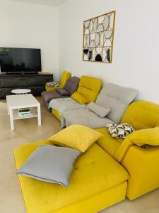 salon z 2 kanapami i żółtą kanapą w obiekcie Très jolie Villa Bianca, maison avec jardin privé à Deauville w mieście Deauville