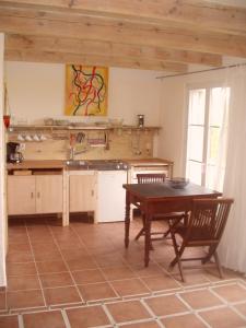 eine Küche mit einem Holztisch sowie einem Tisch und Stühlen in der Unterkunft Hofboddenblick in Kückenshagen