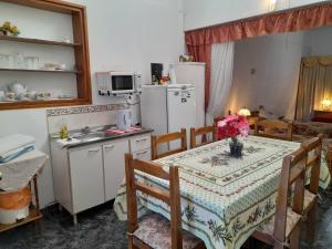 eine Küche mit einem Tisch und eine Küche mit einem Kühlschrank in der Unterkunft Casa una habitación in Colonia del Sacramento
