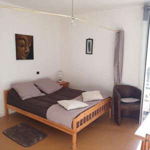 um quarto com uma cama e uma cadeira em Studio Barbotan em Barbotan-les-Thermes