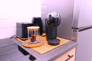 eine Theke mit einer Kaffeemaschine und einem Mixer darauf in der Unterkunft La Cosy House in Courcouronnes