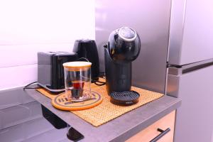 a counter with a coffee maker and a blender on it at La Cosy House in Evry-Courcouronnes