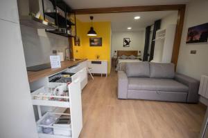 a kitchen and living room with a couch and a table at A Casiña do Camiño in Baamonde