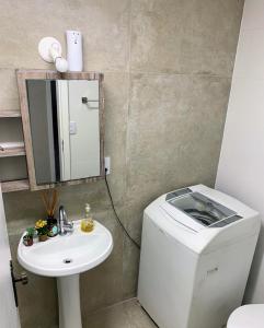 een badkamer met een toilet, een wastafel en een spiegel bij Ap à 170m do mar, Praia dos Ingleses in Florianópolis