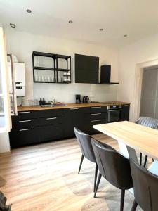 a kitchen with black cabinets and a wooden table at Historic 4 Rooms in Mannheim