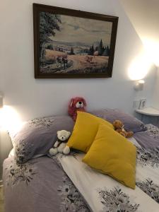 un lit avec deux animaux farcis assis sur lui dans l'établissement Holiday house Apartments Dajčić, à Varaždinske Toplice