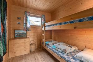 フィアランドにあるCabin alongside the beautiful fjærlandsfjordのログキャビン内のベッドルーム1室(二段ベッド2組付)