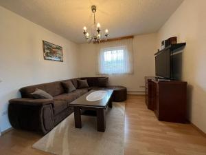 a living room with a couch and a television at Kuća za odmor IVKOVIĆ in Kupres