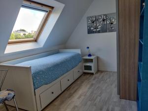 ein kleines Schlafzimmer mit einem Bett und einem Fenster in der Unterkunft Chez la Québécoise - chambre d'hôtes in Bourg-Blanc