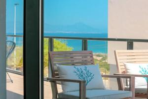 een stoel op een balkon met uitzicht op de oceaan bij Iconic Sea Views Luxury Apartment in Puerto Marino