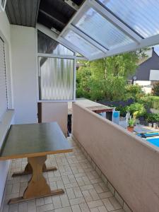 eine Terrasse mit einem Tisch und einem Fenster in der Unterkunft Ferienwohnung Schleiten in Püttlingen