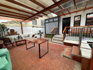 a patio with a wooden table on a balcony at Jolie Joe's Bed and Breakfast in Tagudin