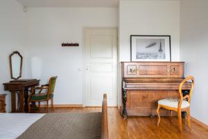 um quarto com um piano, uma cadeira e uma mesa em Old Town - Suur Karja Apartment em Talin