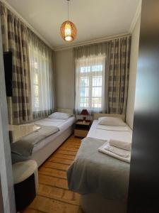 1 dormitorio con 2 camas y ventana en Guest House Lusi, en Tiflis