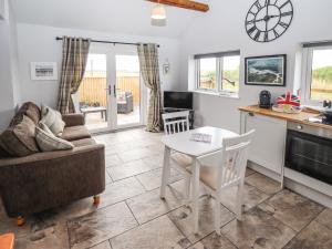 a kitchen and living room with a table and a couch at Sanderlings Cottage in Mablethorpe