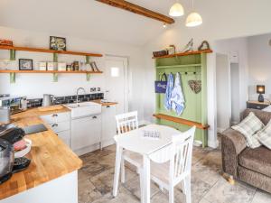 a kitchen and living room with a table and chairs at Sanderlings Cottage in Mablethorpe
