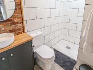 a bathroom with a toilet and a sink and a shower at Sanderlings Cottage in Mablethorpe