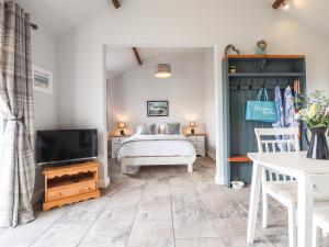 a bedroom with a bed and a flat screen tv at Wagtail Cottage in Mablethorpe