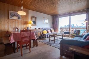 a living room with a table and a living room with a couch at Apartment with a balcony and superb view - Huez - Welkeys in LʼHuez