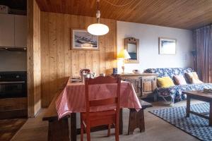 a kitchen with a table and a living room at Apartment with a balcony and superb view - Huez - Welkeys in LʼHuez