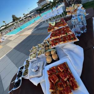 a table with plates of food next to a pool at PoolSide in Irsina