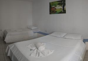 a bedroom with two beds with towels on them at Pousada Nascer do Sol in João Pessoa
