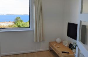 a living room with a large window and a television at Porthpean Apartment in Charlestown