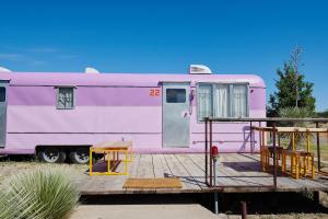 a pink trailer is parked on a wooden deck at El Cosmico in Marfa