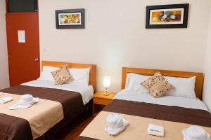 2 camas en una habitación de hotel con toallas en las mesas en Fanda, en Sauce