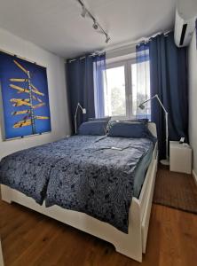 ワルシャワにあるStudio Anielewiczaのベッドルーム1室(青い壁のベッド1台、窓付)