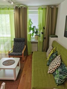 ワルシャワにあるStudio Anielewiczaのリビングルーム(緑のソファ、テーブル付)