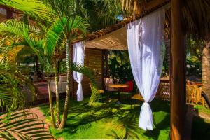 eine Veranda mit weißen Vorhängen sowie einem Tisch und Stühlen in der Unterkunft Boutique Hotel IBIZA in Jacó