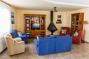 a living room with blue couches and a tv at Casa Rural La Pinta- SendaViva y Bardenas in Villafranca