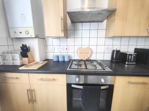 una cocina con fogones con un signo cardiaco en Lovely 3 bedroom serviced apartment in Leytonstone, en Londres