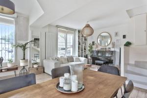 a living room with a table and chairs at Beautiful house with terrace - Puteaux - Welkeys in Puteaux