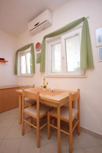 a table and chairs in a room with two windows at Apartments by the sea Slano, Dubrovnik - 8608 in Slano