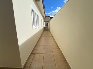 um corredor de um edifício vazio com piso em azulejo em Área Central/3 quartos/grande grupos em Marília
