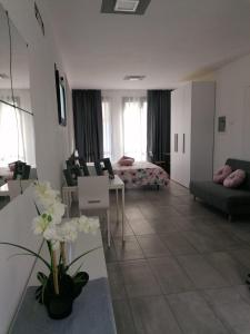 ein Wohnzimmer mit einem Sofa und einem Tisch mit Blumen in der Unterkunft IL CILIEGIO DI ZOE in Cerro Lago Maggiore