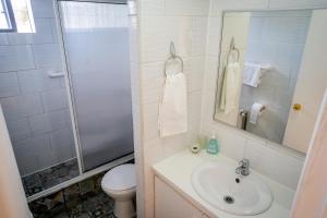 y baño con lavabo, aseo y ducha. en Casa Lucy, en Puerto Natales